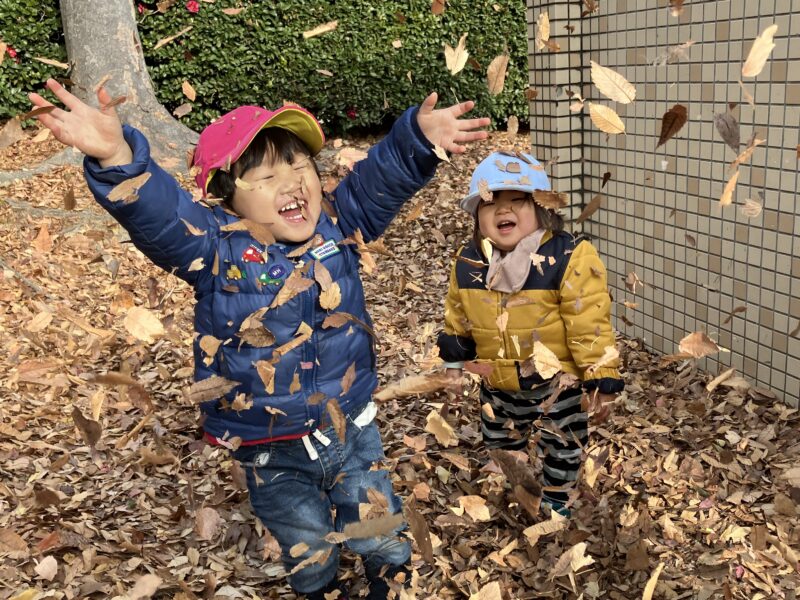 落ち葉遊びをする子どもたち